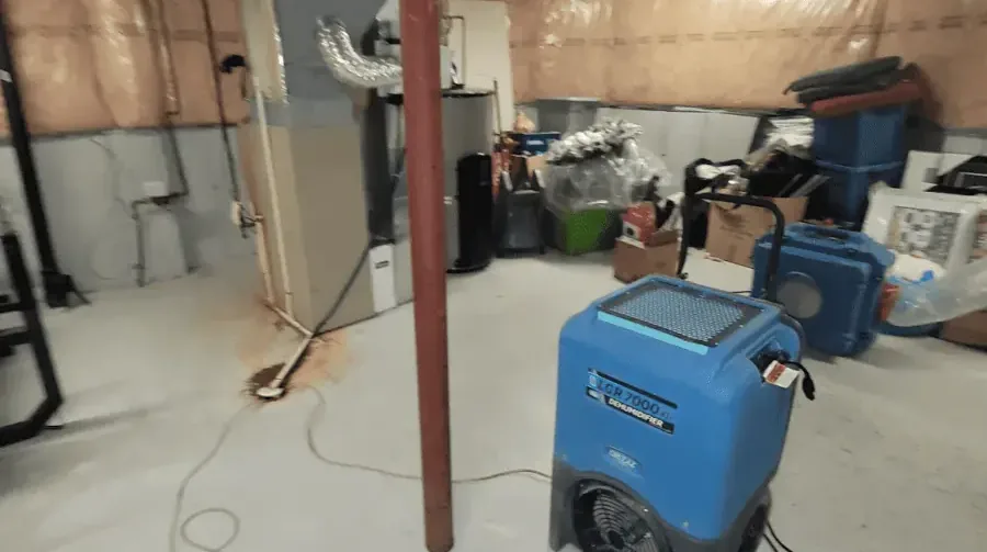 Dehumidifier running in a lower room during structural drying